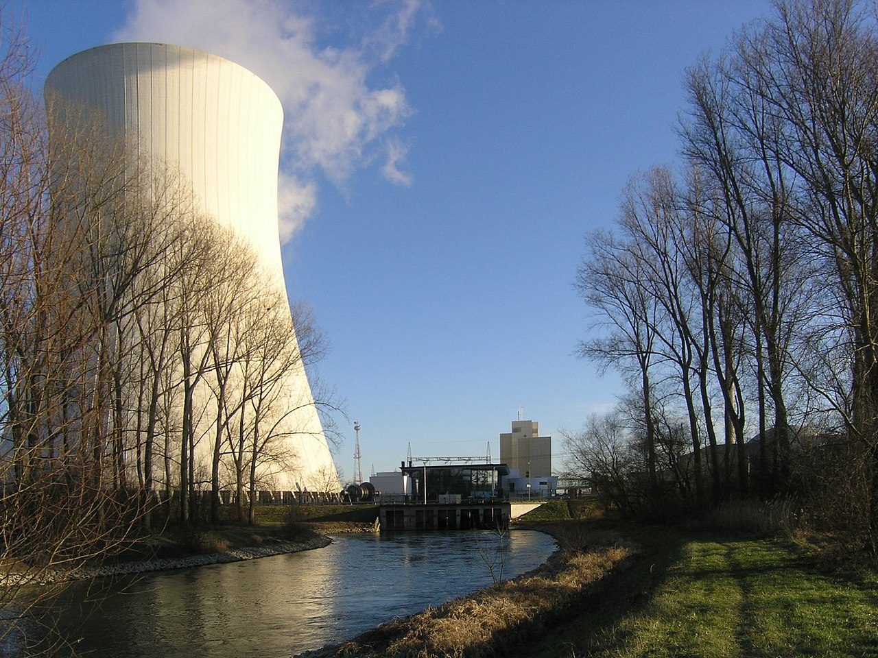 Großer Naturzug-Kühlturm mit Dampffahne an einem Fluss