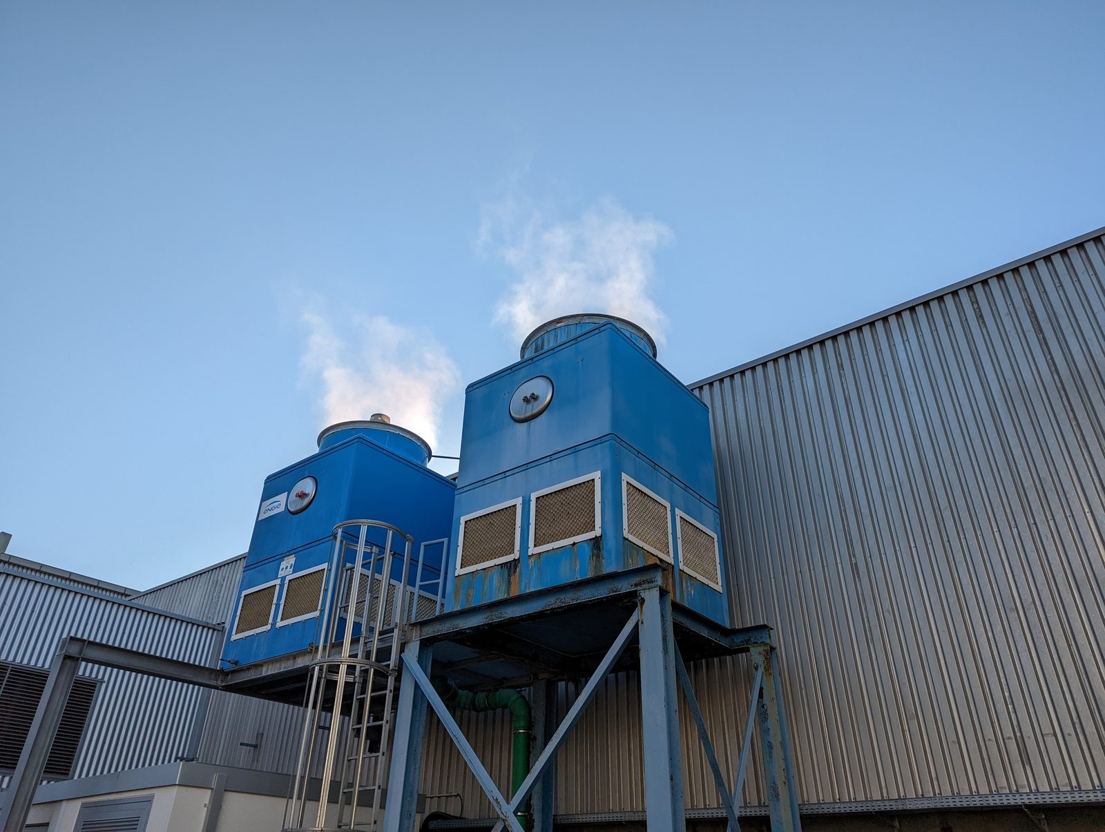 Zwei blaue Verdunstungskühltürme auf dem Dach einer Industriehalle